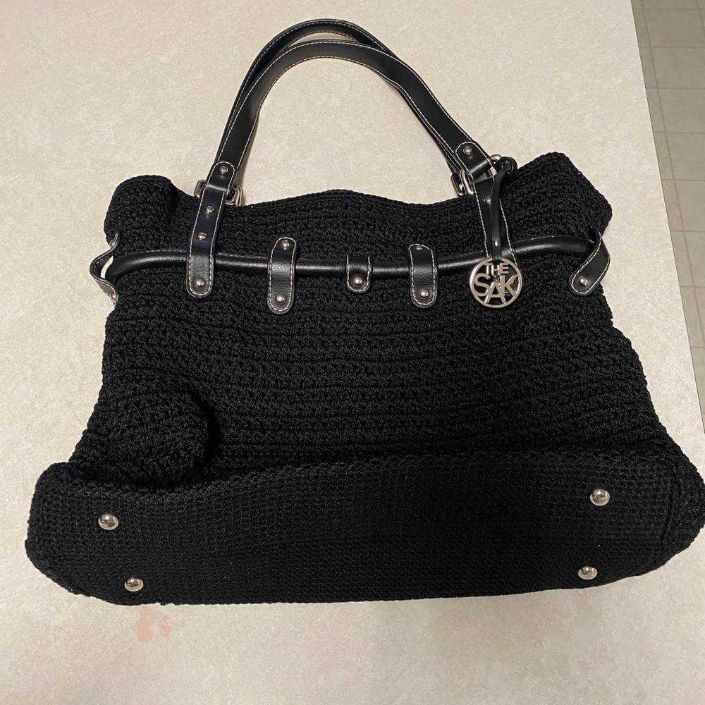 The Sak women black and with silver knit accents hand bag.
